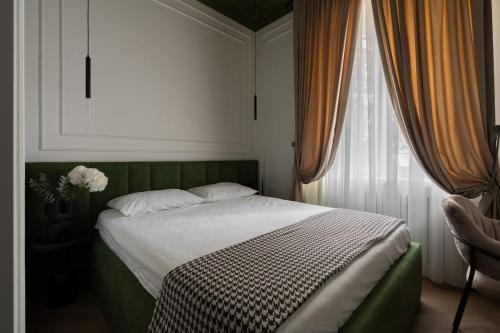 Un dormitorio con una cama verde y una ventana. en Elegant central apartment, en Toshkent-Passajir Bekati