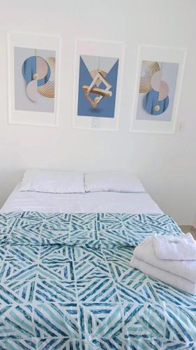 a bed in a room with pictures on the wall at Apto 5 pessoas - Prox FIP e Stop Shop in Brusque