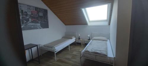 a small room with two beds and a window at Reihenendhaus bei Nürnberg in Petersaurach
