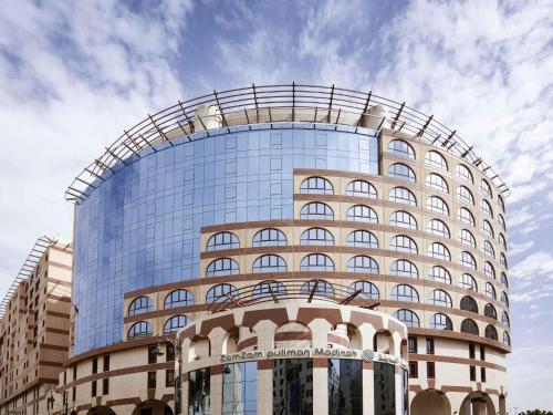 a large glass building with a curved roof at Zamzam Pullman Madina in Al Madinah