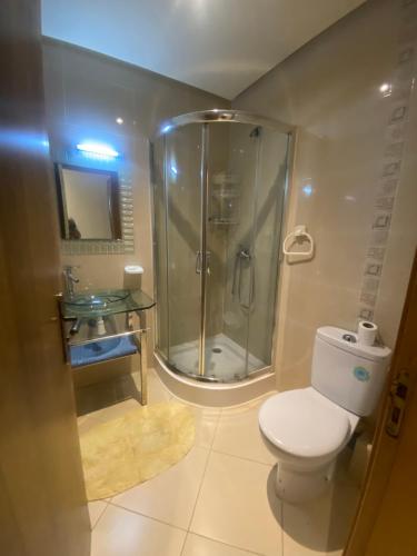 a bathroom with a shower and a toilet and a sink at Golf 47 A in Asilah