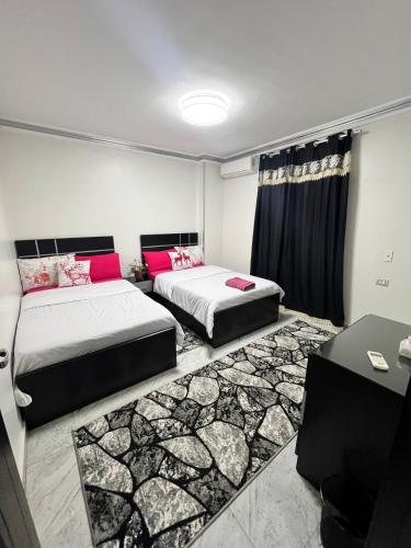 een kamer met twee bedden en een tafel erin bij Hi Pyramids in Caïro