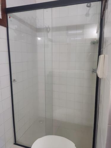 a bathroom with a glass shower with a toilet at Apartamento Estúdio Beira Mar in Ilhéus