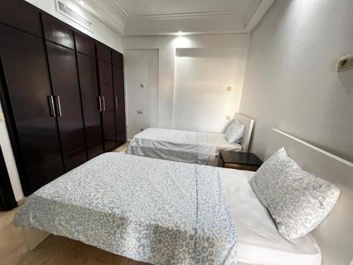 a hotel room with two beds and a chair at Corniche Casablanca in Casablanca