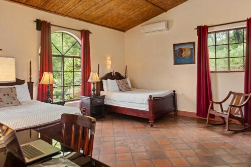 a bedroom with two beds and a table with a laptop at Nicawaves in Popoyo
