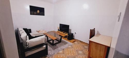 a living room with a couch and a table at Joy's One Bedroom Apartment in Kitale