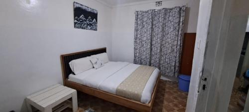 a small bedroom with a bed and a window at Joy's One Bedroom Apartment in Kitale
