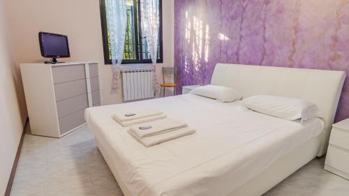 a bedroom with a white bed with towels on it at Il Giardino Segreto - Italian Homing in Rivoltella