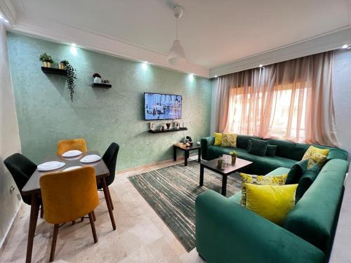 a living room with a green couch and a table at Corniche Casablanca in Casablanca