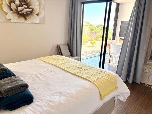 een slaapkamer met een bed en een glazen schuifdeur bij 105 Gouriqua Mosselbay in Mosselbaai
