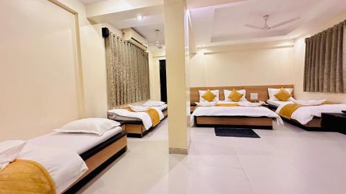 ein Hotelzimmer mit zwei Betten in einem Zimmer in der Unterkunft Hotel Sai Gurusthan in Shirdi