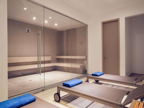 a gym with two benches and a glass wall at Mercure Santa Marta Emile in Santa Marta