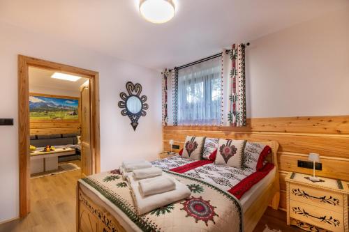 a bedroom with a bed and a mirror on the wall at Apartament Pod Magurą in Witów