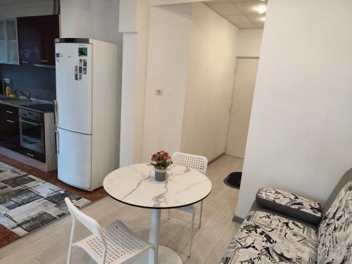 a living room with a table and a white refrigerator at Стаи за гости Ве-Бо-Ли** in Bankya