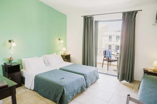 a hotel room with a bed and a balcony at Likithos Village in Agios Georgios