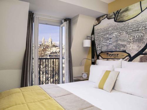 ein Schlafzimmer mit einem Bett und einem Fenster mit Aussicht in der Unterkunft Mercure Paris Pigalle Sacre Coeur in Paris