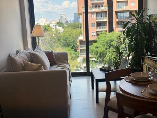 a living room with a couch and a large window at Soneto 603 in Guadalajara