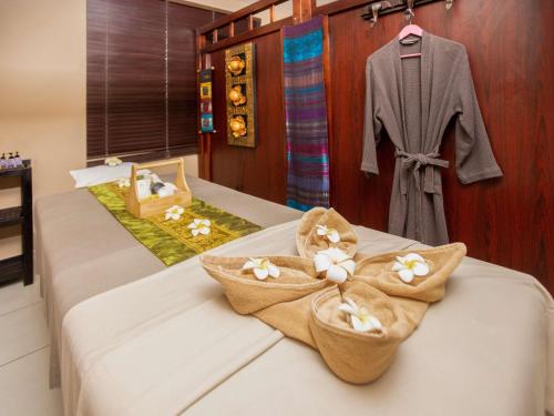 a bedroom with a bed with towels and a robe at Ibis Styles Accra Airport in Accra