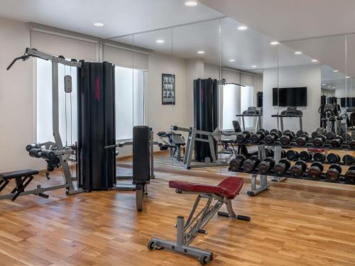 a gym with several treadmills and weights at Ibis Styles Dragon Mart Dubai in Dubai