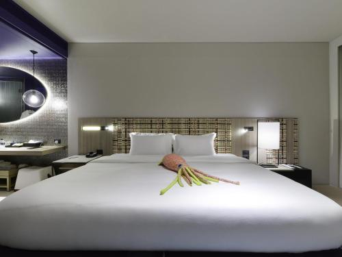 a large white bed with a fish on it at Veranda Resort Pattaya - MGallery Collection, Accor Hotel in Jomtien Beach