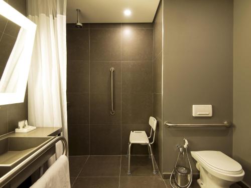 a bathroom with a shower with a toilet and a sink at Novotel Santos Gonzaga in Santos