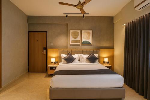 a bedroom with a large bed and a ceiling fan at Dlite Rivera Luxury Service Apartments in Bengaluru