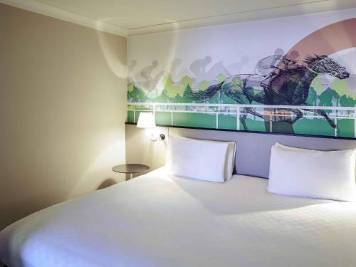 um quarto de hotel com uma cama e um quadro na parede em Mercure Haydock Hotel em Haydock