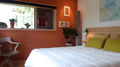 Un dormitorio con una cama blanca y una ventana. en Gite Dilos, en Rébénacq