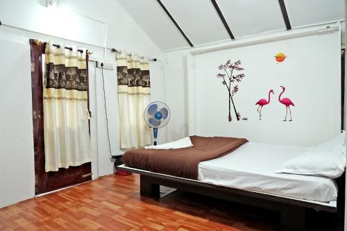奇克马格尔Jungle Greens Homestay - Water Activities, Near to Jungle Safari的卧室配有一张壁挂有火烈鸟的床