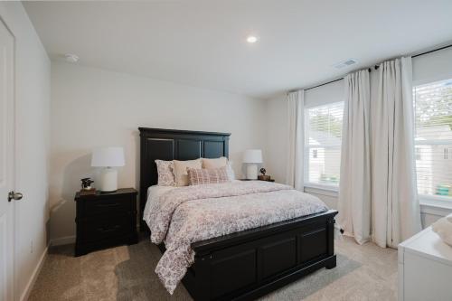 a bedroom with a black bed and a window at Spacious Bluffton Retreat for Families & Friends in Bluffton