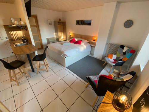 a hotel room with a bed and a table and chairs at L'Oustal Des Dômes in Orcines