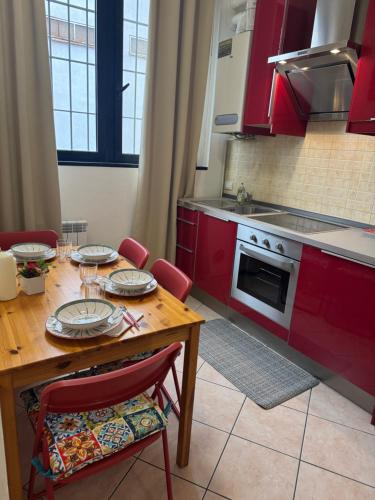 a kitchen with a wooden table and red cabinets at Aparthotel Dergano 3 near metro stop in Milan