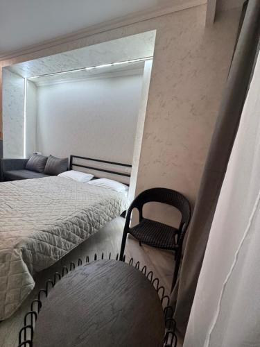 een slaapkamer met een bed en een stoel erin bij Alvina Complex Apartment in Tsachkadzor