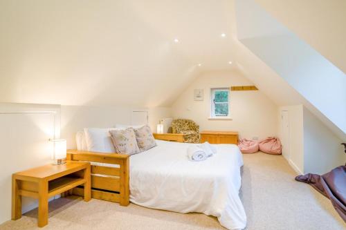 a bedroom with a large white bed and a table at 5 Bed in Corfe Castle DC061 in Corfe Castle