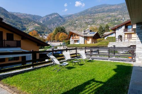 two chairs on a lawn with mountains in the background at La Maison de L'Adret in Saint-Pierre