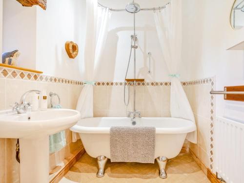 a bathroom with a bath tub and a sink at 3 Bed in Eden Valley 93200 in Colby