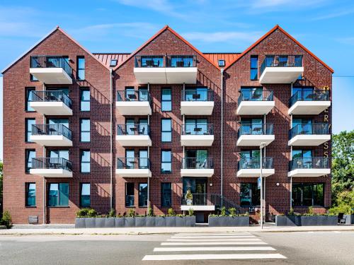 un edificio de apartamentos con balcones en una calle en Überwasser Hotel, en Cuxhaven