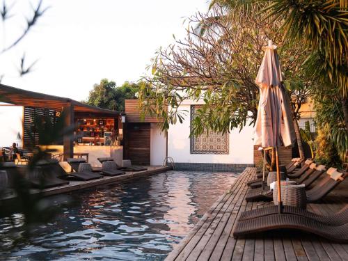 a swimming pool with lounge chairs and an umbrella at Santa Teresa Hotel Rio de Janeiro - MGallery Collection in Rio de Janeiro
