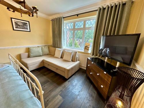 Una sala de estar con un sofá y un televisor de pantalla plana. en STUNNING Character Home , Rustic Charm Meets Modern Living, en Welling
