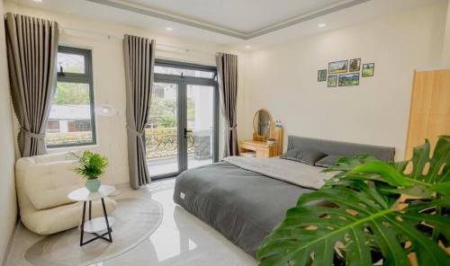 a bedroom with a bed and a chair and a window at Amy Hotel & Apartment in Da Thanh