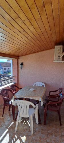 a table and chairs sitting under a wooden ceiling at Apartman Marija 2 in Kraljevo