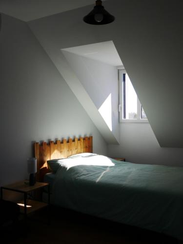 a bedroom with a bed and a window at Loc' Maria - Grands Sables in Groix