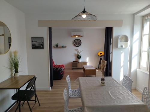 a dining room and living room with a table and chairs at Appart 2 Chambres, Proche Gare, Wifi, Jardin, Parking in Montélimar