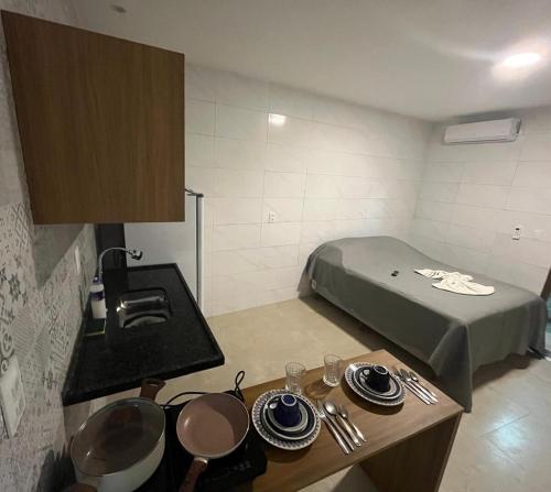 Camera piccola con letto e tavolo con piatti di Conforto e Tranquilidade - Excelente Estadia a Recife