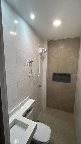 a white bathroom with a toilet and a shower at Conforto e Tranquilidade - Excelente Estadia in Recife
