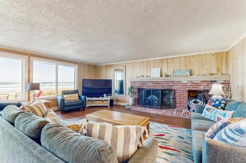 a living room with a couch and a fireplace at Oceanfront home with a washer dryer and beach access in Rockaway Beach