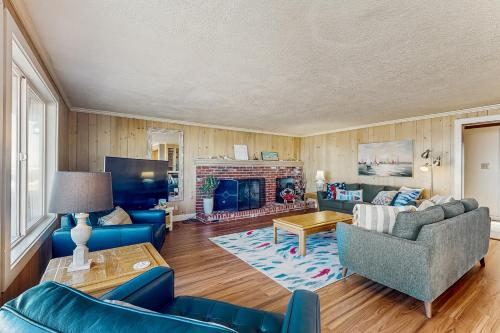 a living room with blue furniture and a fireplace at Oceanfront home with a washer dryer and beach access in Rockaway Beach