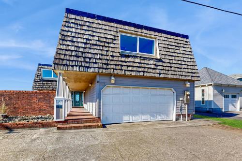 a blue house with a garage at Oceanfront home with a washer dryer and beach access in Rockaway Beach