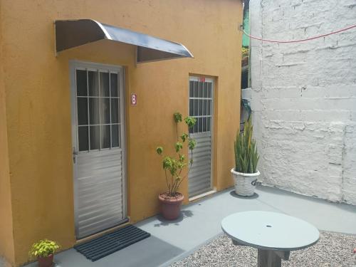 un patio avec deux portes et une table et des plantes dans l'établissement Hospede-se no IPSEP , em Recife , próximo ao Aeroporto Internacional dos Guararapes, à Récife