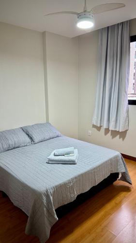 una camera da letto con un letto con due asciugamani sopra di Apartamento moderno a 2 quadras da Praia da Costa - completo, espaçoso e com mimo especial a Vila Velha